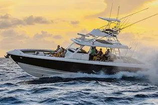 Slide: The Image of Manufacturer Provided Image: 2025 Everglades 455 Center Console boat cruising at sunset on open water. - 2