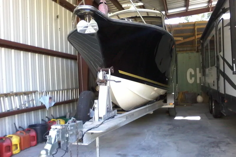 The Image of 2002 Albemarle 265 Express Fisherman boat on trailer, surrounded by trees. - 0