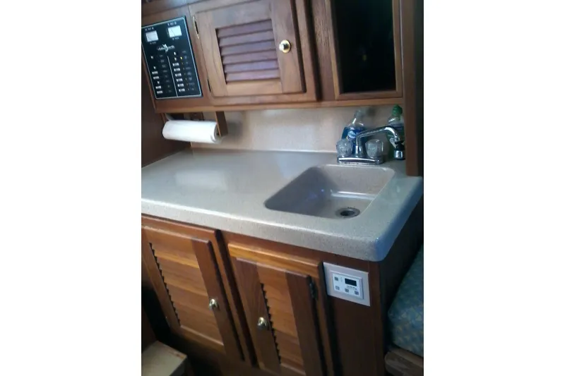 Slide: The Image of 2002 Albemarle 265 Express Fisherman boat interior with sink and wooden cabinetry. - 20