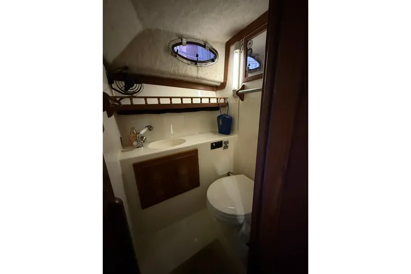 Slide: The Image of 2002 Albemarle 265 Express Fisherman boat bathroom with sink, toilet, and porthole window. - 25