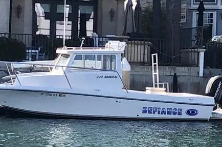 Slide: The Image of 2015 Defiance 220 Admiral EX boat docked by waterfront homes. - 1