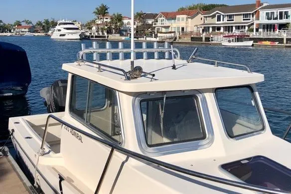 Slide: The Image of 2015 Defiance 220 Admiral EX boat docked in a scenic waterfront area. - 8