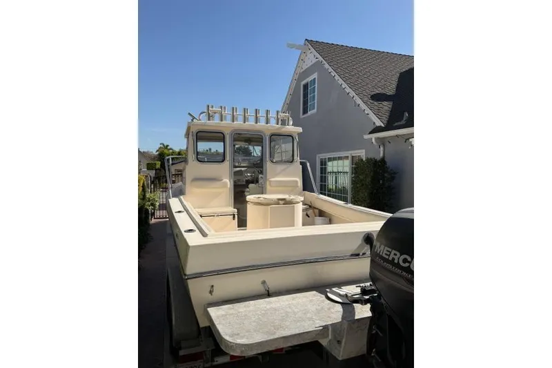 Slide: The Image of 2015 Defiance 220 Admiral EX boat parked near a house, featuring a Mercury outboard motor. - 9