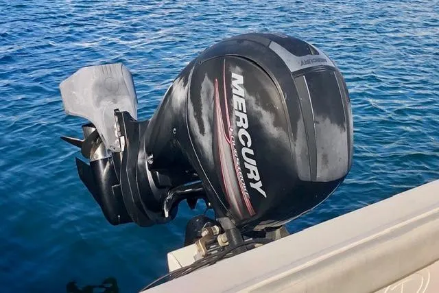 Slide: The Image of Outboard motor on 2015 Defiance 220 Admiral EX boat in blue water. - 11