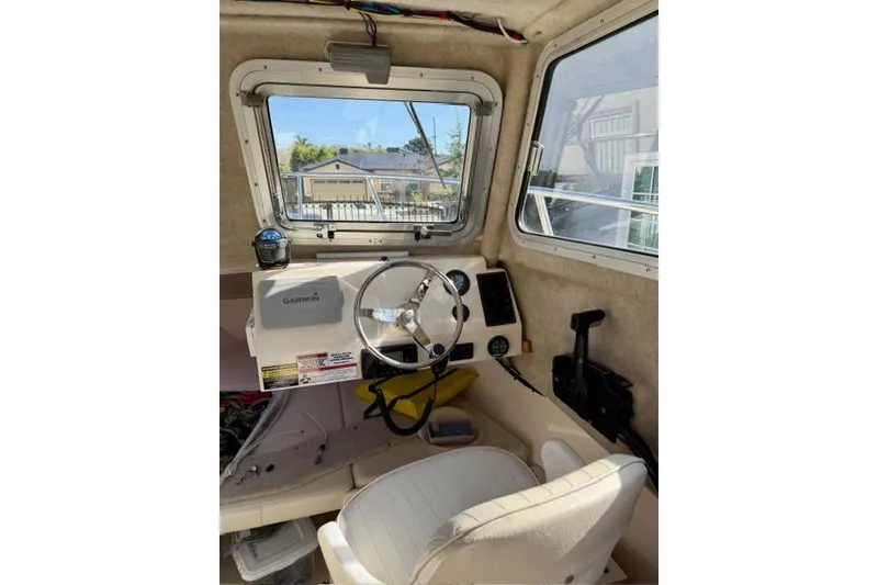 Slide: The Image of Interior of a 2015 Defiance 220 Admiral EX boat with steering wheel and Garmin device. - 16