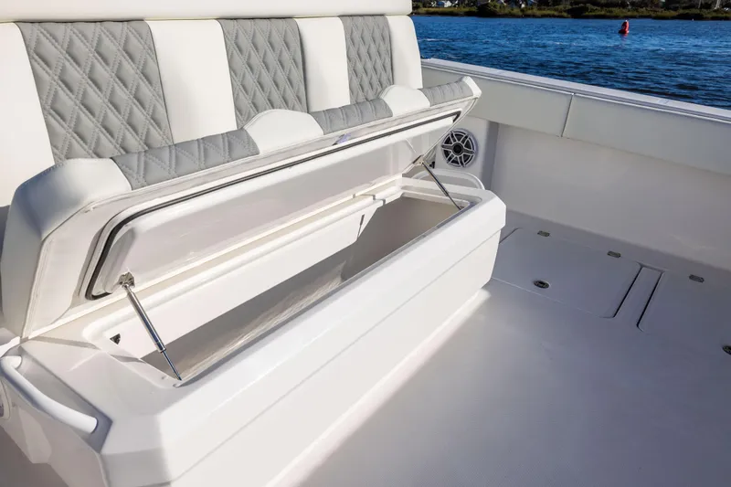 Slide: The Image of 2026 Invincible 38 Catamaran with open storage compartment, luxury seating, and ocean view. - 17