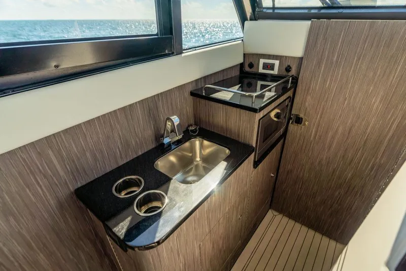 Slide: The Image of Compact kitchenette in 2026 Invincible 46 Pilothouse with sink, stove, and ocean view. - 12