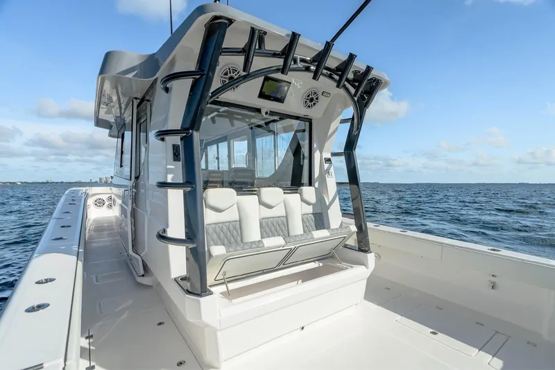 Slide: The Image of 2026 Invincible 46 Pilothouse boat on open water, showcasing sleek design and seating. - 14