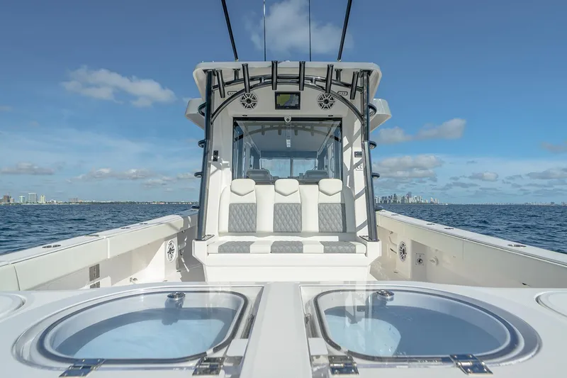 Slide: The Image of Manufacturer Provided Image: 2026 Invincible 46 Pilothouse boat on open water, clear sky, city skyline in background. - 5