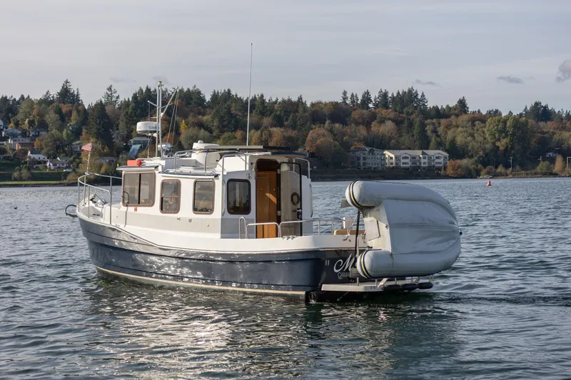 Slide: The Image of 2012 Ranger Tugs R-25 SC boat on calm water with scenic shoreline background. - 2