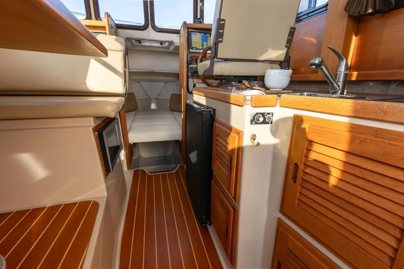 Slide: The Image of Interior of 2012 Ranger Tugs R-25 SC boat with wood finishes and compact kitchen area. - 8