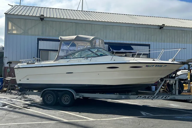 Slide: The Image of 1985 Sea Ray 255 SVR boat on trailer outside a warehouse. - 12