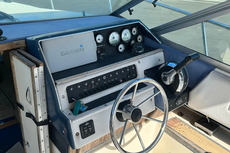 Slide: The Image of 1985 Sea Ray 255 SVR boat dashboard with Garmin navigation system and steering wheel. - 4