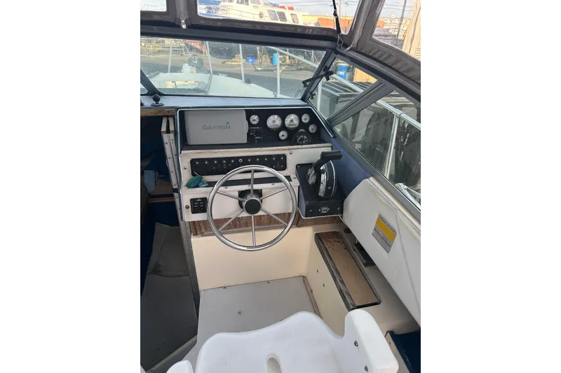 Slide: The Image of 1985 Sea Ray 255 SVR boat cockpit with steering wheel and Garmin navigation system. - 5