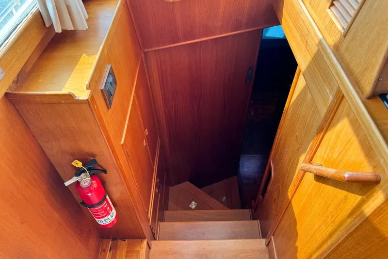 Slide: The Image of Wooden staircase inside 2000 Grand Banks 52 Europa yacht with fire extinguisher. - 20