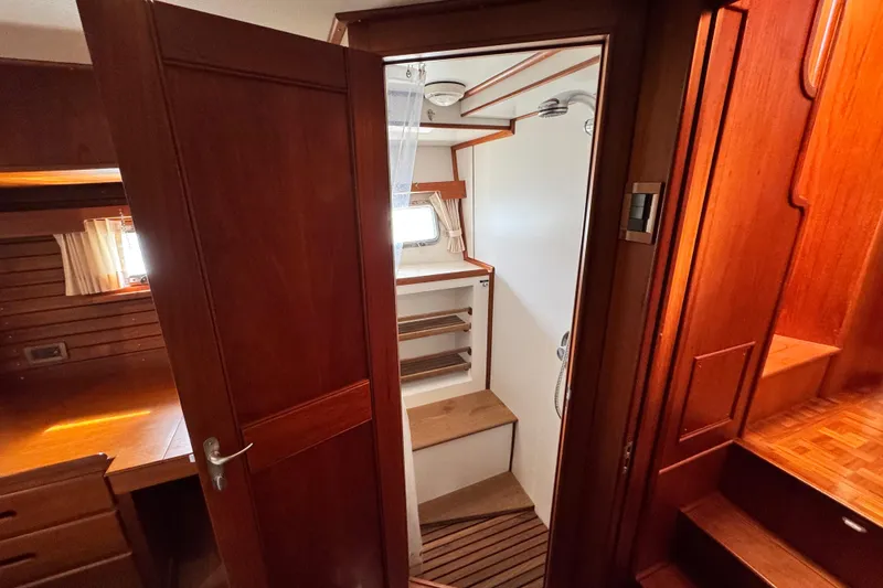 Slide: The Image of Interior of 2000 Grand Banks 52 Europa yacht, featuring wooden cabinetry and compact shower area. - 29