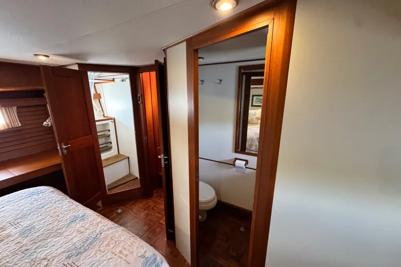 Slide: The Image of Interior of 2000 Grand Banks 52 Europa yacht, featuring bedroom and bathroom with wooden accents. - 30