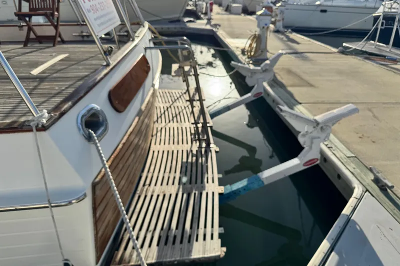 Slide: The Image of Grand Banks 52 Europa yacht docked at marina, showing boarding platform and mooring lines. - 50