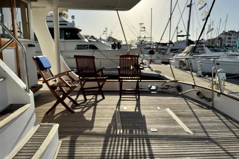 Slide: The Image of Deck of 2000 Grand Banks 52 Europa yacht with wooden chairs at marina. - 52
