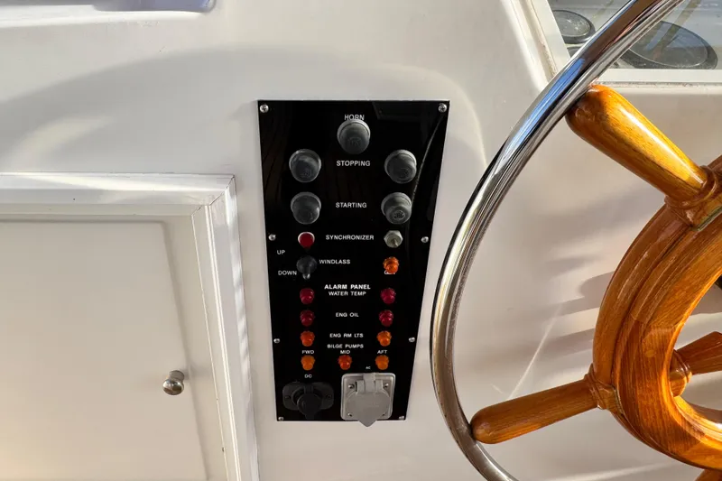 Slide: The Image of Control panel and wooden steering wheel on a 2000 Grand Banks 52 Europa yacht. - 56