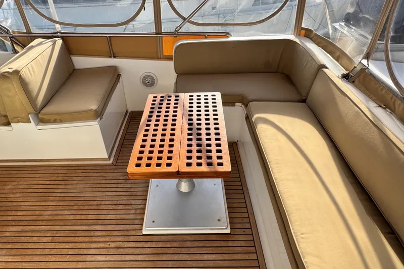 Slide: The Image of Luxurious seating area on 2000 Grand Banks 52 Europa yacht with wooden table and cushions. - 62