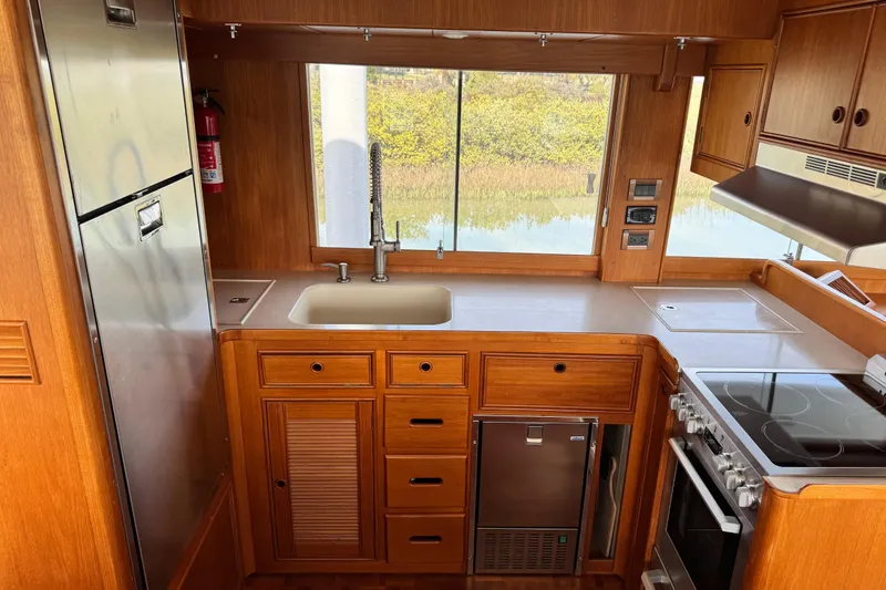 Slide: The Image of Kitchen area of 2000 Grand Banks 52 Europa yacht with wooden cabinetry and modern appliances. - 8