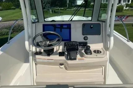 Slide: The Image of 2023 Boston Whaler 280 Dauntless helm with steering wheel and navigation controls. - 11