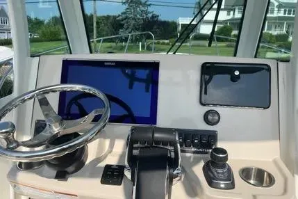 Slide: The Image of 2023 Boston Whaler 280 Dauntless helm with steering wheel and navigation display. - 12