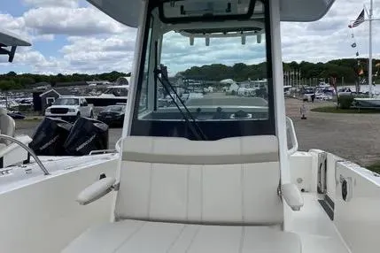 Slide: The Image of 2023 Boston Whaler 280 Dauntless boat interior with seating and console, docked at marina. - 17