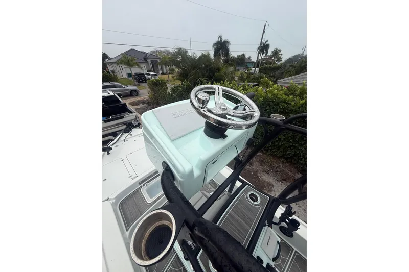 Slide: The Image of 2020 Yellowfin 24 Bay CE boat helm with steering wheel and controls, outdoor setting. - 4