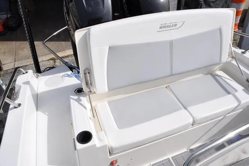 Slide: The Image of 2016 Boston Whaler 270 Dauntless boat seating area with white cushions and cup holders. - 12
