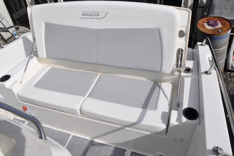 Slide: The Image of 2016 Boston Whaler 270 Dauntless boat seating area with white cushions and cup holders. - 13