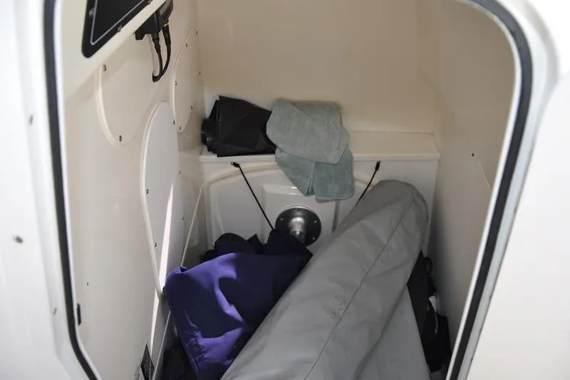 Slide: The Image of Storage compartment inside 2016 Boston Whaler 270 Dauntless boat, containing various items. - 23