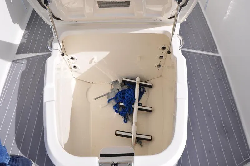 Slide: The Image of Open storage compartment on 2016 Boston Whaler 270 Dauntless boat with blue rope and anchor. - 26