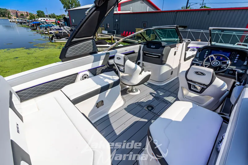 Slide: The Image of 2026 Chaparral SSX 6 boat interior with modern seating and dashboard, docked by a marina. - 10