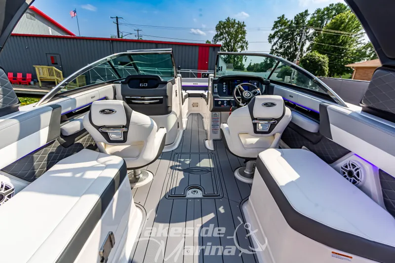 Slide: The Image of 2026 Chaparral SSX 6 boat interior with modern seating and dashboard, docked at marina. - 11