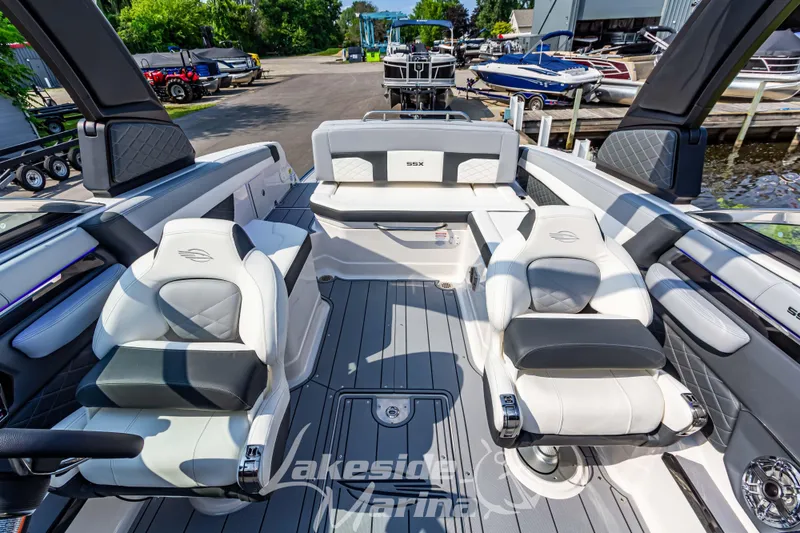Slide: The Image of 2026 Chaparral SSX 6 boat interior with luxurious seating and modern design at a marina. - 24