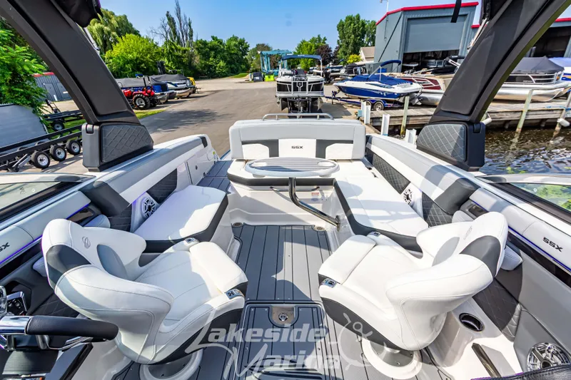 Slide: The Image of 2026 Chaparral SSX 6 boat interior with luxurious seating and sleek design at a marina. - 26