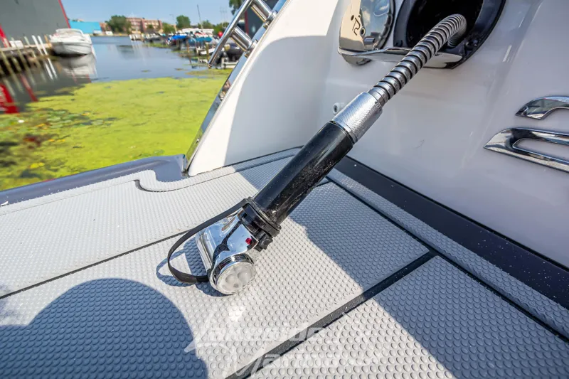 Slide: The Image of 2026 Chaparral SSX 6 boat with a fuel hose on deck, dockside view. - 5