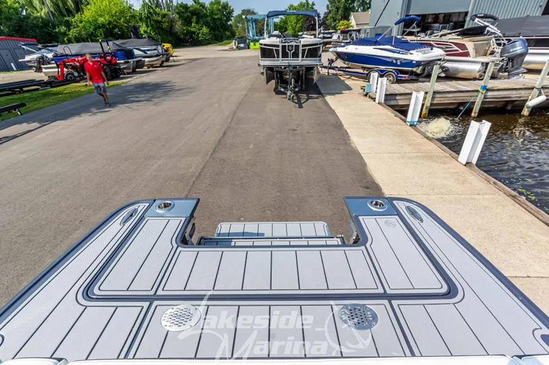 Slide: The Image of 2026 Chaparral SSX 6 boat at marina dock, surrounded by other boats and greenery. - 6