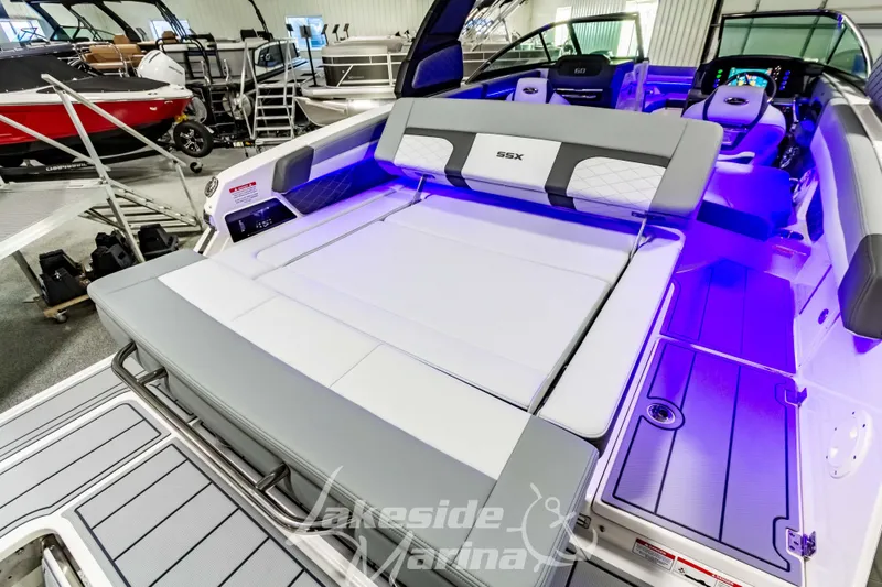Slide: The Image of 2026 Chaparral SSX 6 boat interior with luxurious seating and ambient lighting in a showroom. - 3