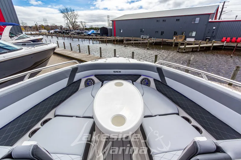 Slide: The Image of 2026 Chaparral SSX 6 boat interior with seating and table, docked at marina. - 32