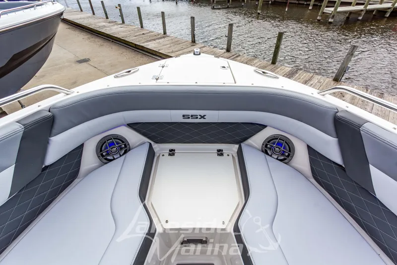Slide: The Image of 2026 Chaparral SSX 6 boat interior with cushioned seating and speakers at a dock. - 35