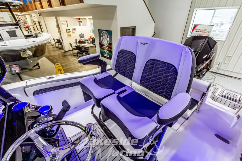 Slide: The Image of 2026 Tidewater 210 CC Adventure boat interior with modern seating in showroom. - 24