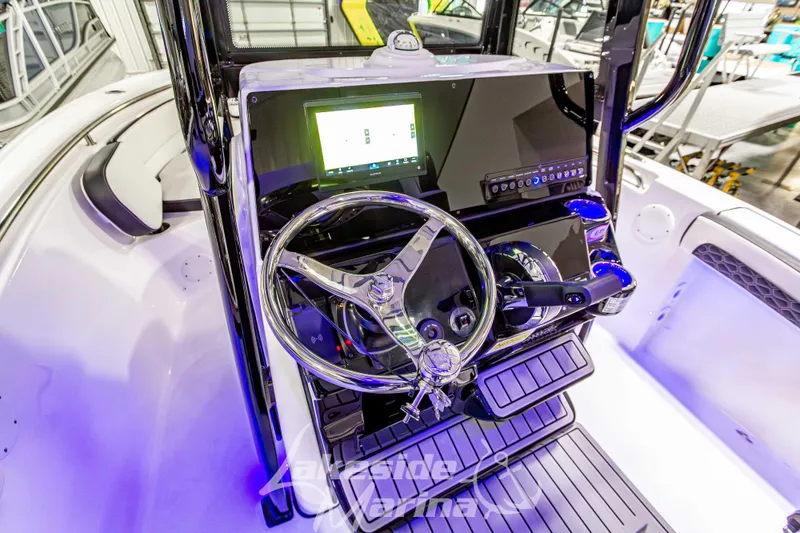 Slide: The Image of 2026 Tidewater 210 CC Adventure boat dashboard with steering wheel and digital display. - 26