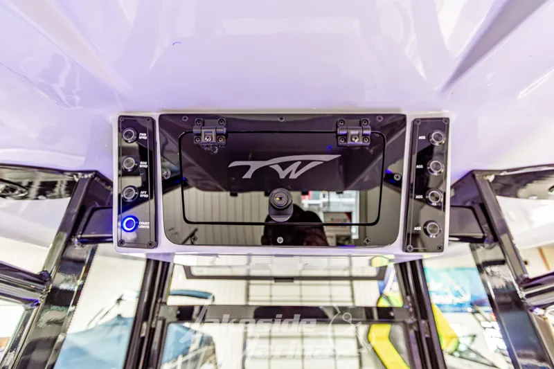 Slide: The Image of 2026 Tidewater 210 CC Adventure boat console with control panel and storage compartment. - 28