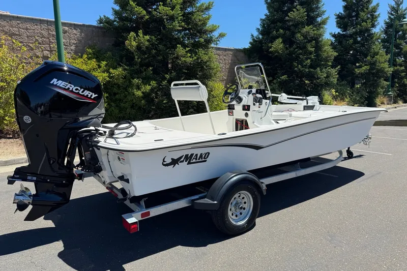 Slide: The Image of 2026 Mako Pro Skiff 17 CC boat with Mercury engine on trailer, parked outdoors. - 5