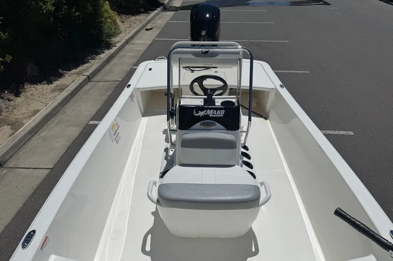 Slide: The Image of 2026 Mako Pro Skiff 17 CC boat, white interior, parked on asphalt. - 14
