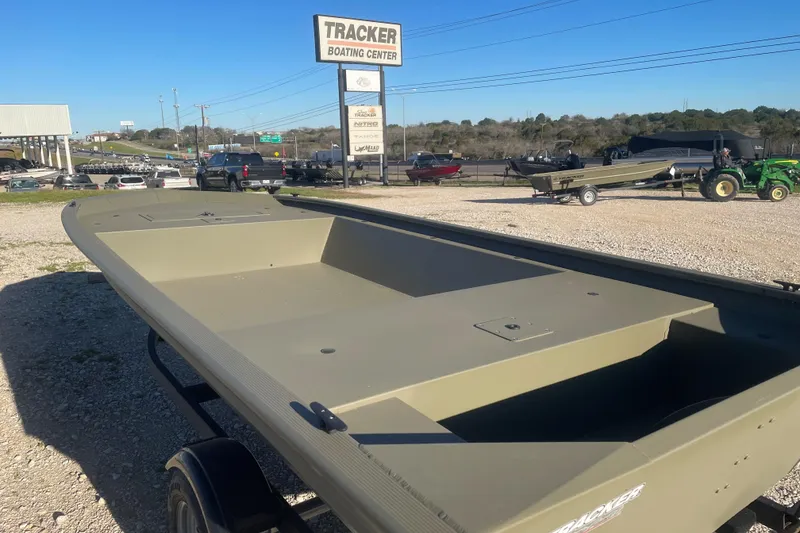 Slide: The Image of 2026 Tracker Grizzly 1648 Utility boat at dealership, sunny day, outdoor display. - 2