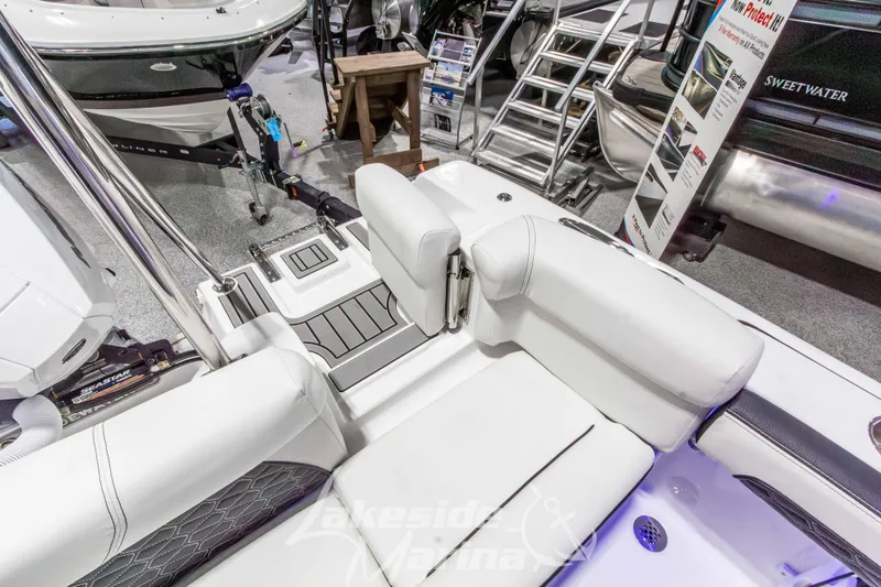 Slide: The Image of 2026 Tidewater 220 LXF boat interior with white seating at a marina display. - 15